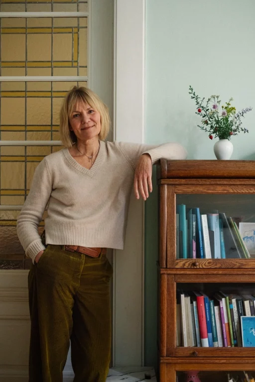 Gesa stehend am Bücherregal